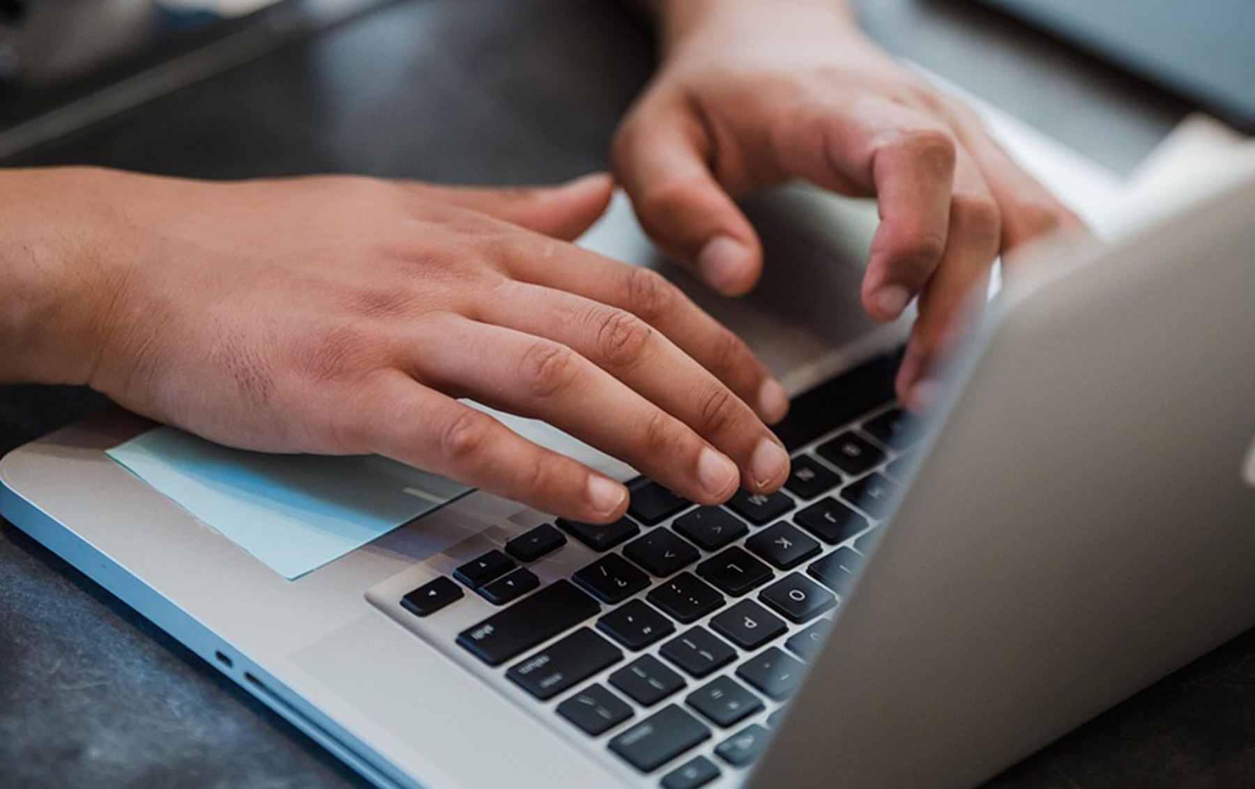 Hände beim Tippen auf Laptop